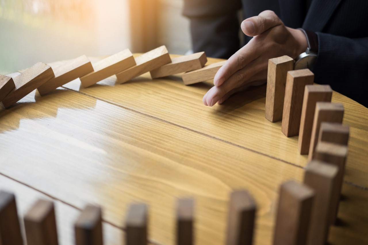 finger holding up wooden blocks